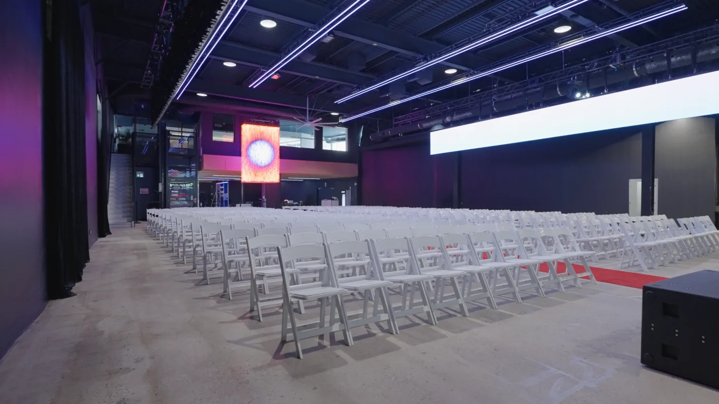 Demo Room set with rows of seating and a red carpet ahead of a conference